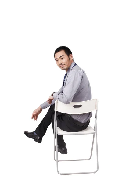 Ένας χαρούμενος νέος επιχειρηματίας κάθεται στάση του σώματος — Φωτογραφία Αρχείου