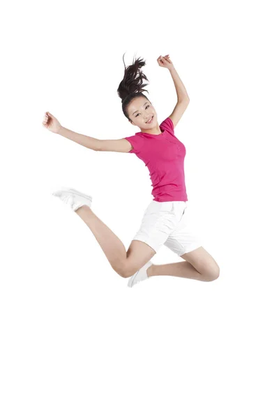 Mujer joven saltando en el aire con los brazos extendidos —  Fotos de Stock