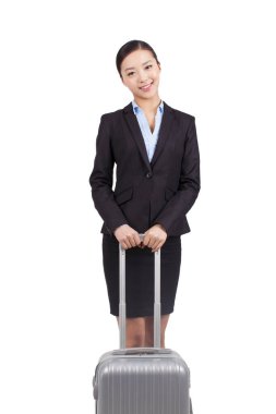 Genç bir iş kadını bavulla yürüyor. 