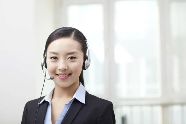 Ung kvinnlig kontorsarbetare i headset-porträtt — Stockfoto