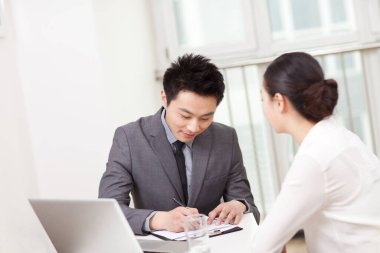 Bir grup iş adamı ofiste tartışıyor.