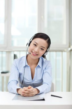 Kulaklık takan genç bir ofis çalışanı.