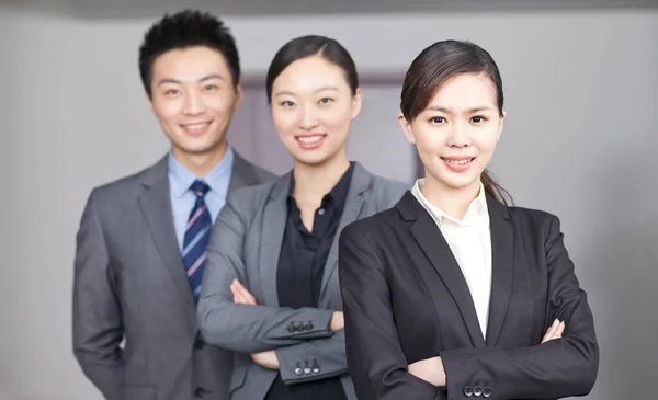 Quatre jeunes employés de bureau les mains croisées à l'intérieur, portrait — Photo