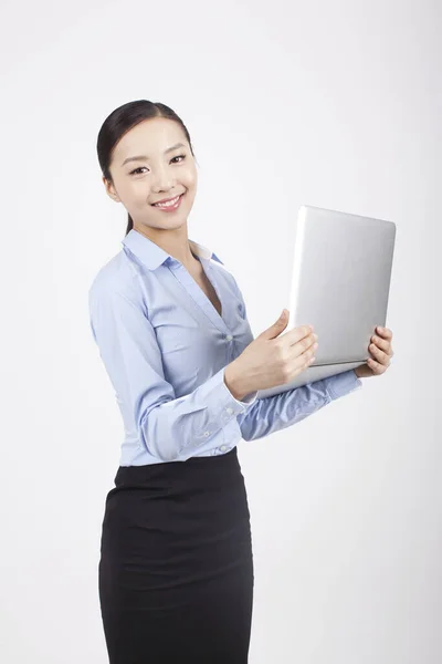 Gülümseyen genç iş kadını elinde dizüstü bilgisayarla — Stok fotoğraf