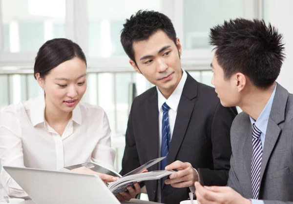 Grupo de empresários discutindo com uma revista no escritório — Fotografia de Stock