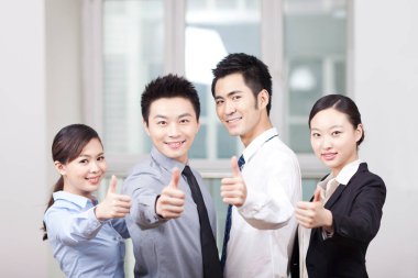 Bir grup genç iş adamı başparmak işareti veriyor.