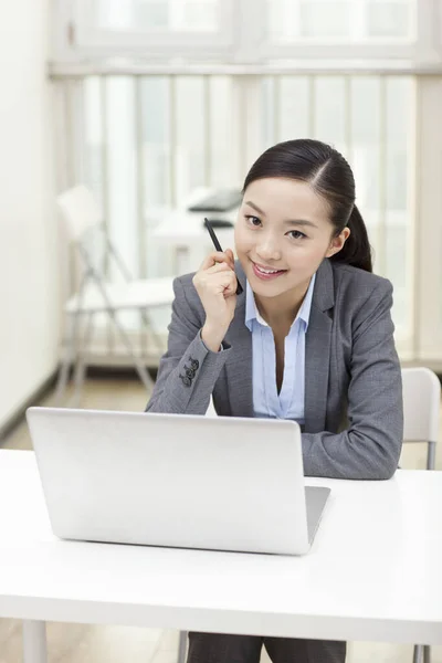 Jovem mulher sentada na frente do laptop — Fotografia de Stock