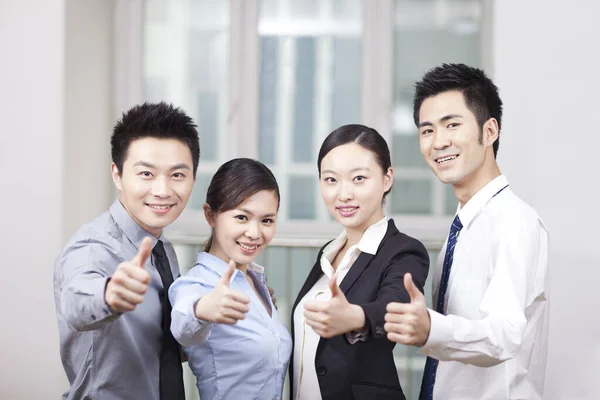 Grupo de jovens empresários dando o sinal Thumbs-up — Fotografia de Stock