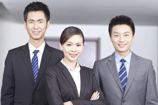 Четыре молодых офисных работника с руками, скрещенными в помещении, портрет — стоковое фото