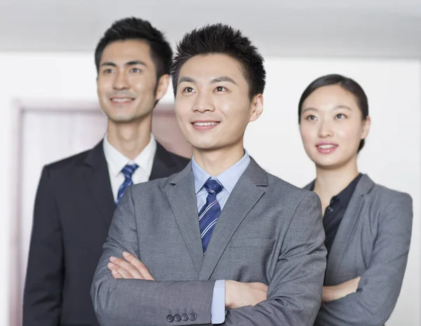 Четыре молодых офисных работника с руками, скрещенными в помещении, портрет — стоковое фото