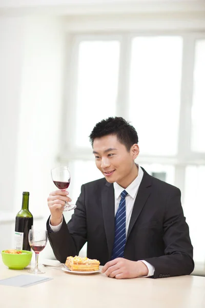 Retrato de homem de negócios na mesa com um copo de vinho — Fotografia de Stock