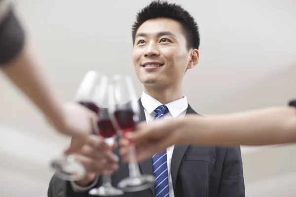 Retrato de empresário segurando um copo de vinho e brindando — Fotografia de Stock