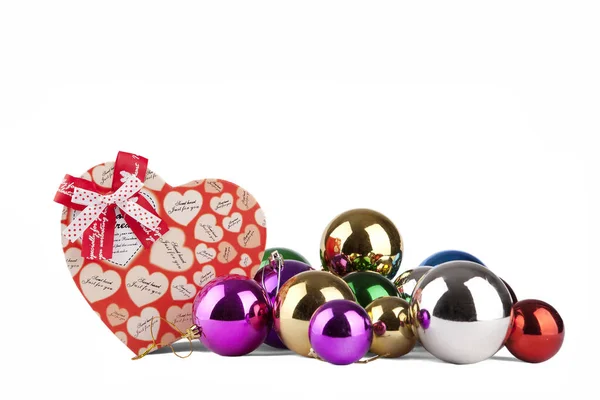 Hjärtformade presentförpackning flerfärgade bollar närbild på en vit bakgrund — Stockfoto