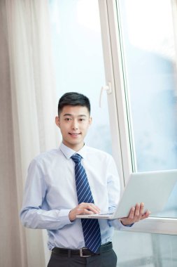 Dizüstü bilgisayarlı genç adamın portresi.