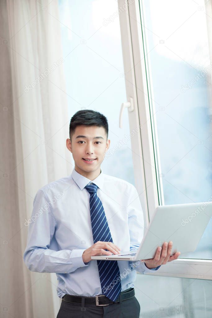 Portrait of young bisiness man with laptop