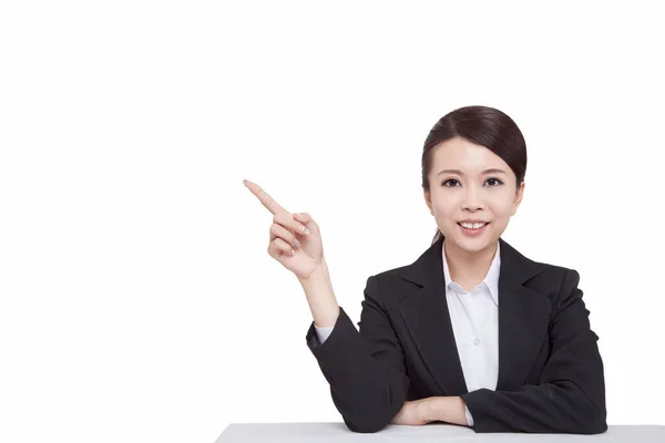 Portrait of young businesswoman sitting at desk,pointing something — Stock Photo, Image