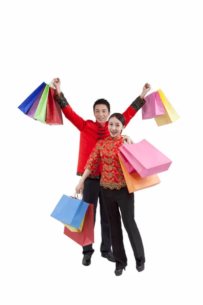 Retrato de pareja joven en trajes Tang, sosteniendo bolsas de compras — Foto de Stock