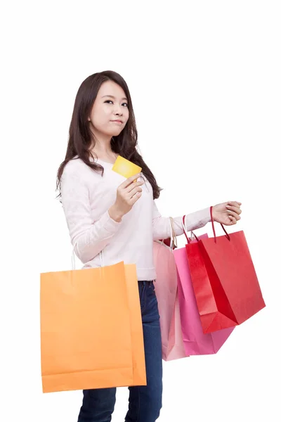 Kredi kartı tutan genç bir kadının portresi, alışveriş torbalarıyla. — Stok fotoğraf