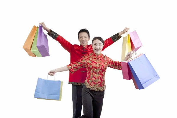 Retrato de pareja joven en trajes Tang, sosteniendo bolsas de compras — Foto de Stock