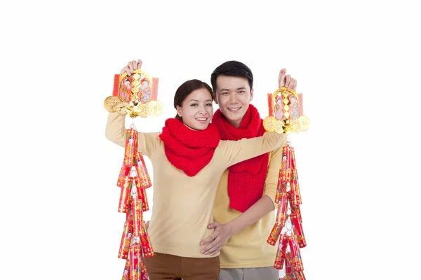 Portrét mladého páru držícího petardy, platící novoroční návštěvu — Stock fotografie