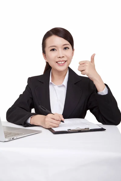 Portrait of young businesswoman sitting at desk with thumb up — Stock Photo, Image