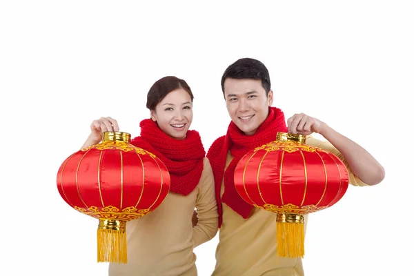 Portrét mladého páru s červenými lucernami, platící novoroční návštěvu — Stock fotografie