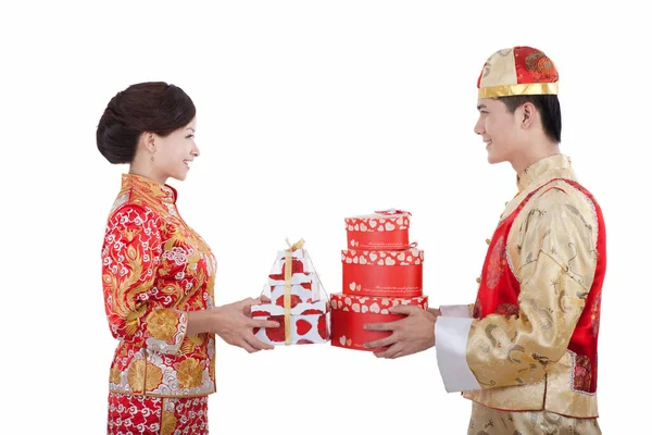 Retrato de jovem casal em ternos Tang segurando presentes — Fotografia de Stock