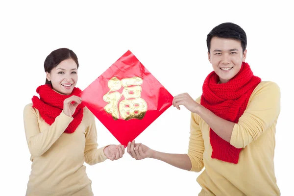 Mladý pár drží čínské štěstí Fu, placení novoroční volání — Stock fotografie