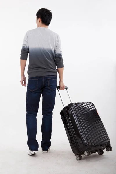 Portret van de jonge bisiness man trekken valise — Stockfoto