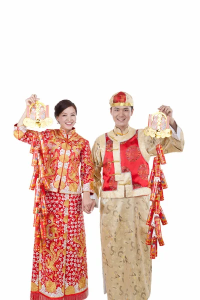Молодая пара в костюмах Тан держит петарды, празднует — стоковое фото