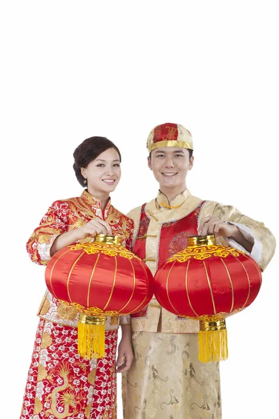 Jovem casal em ternos Tang pagando chamada de Ano Novo segurando lanternas vermelhas — Fotografia de Stock