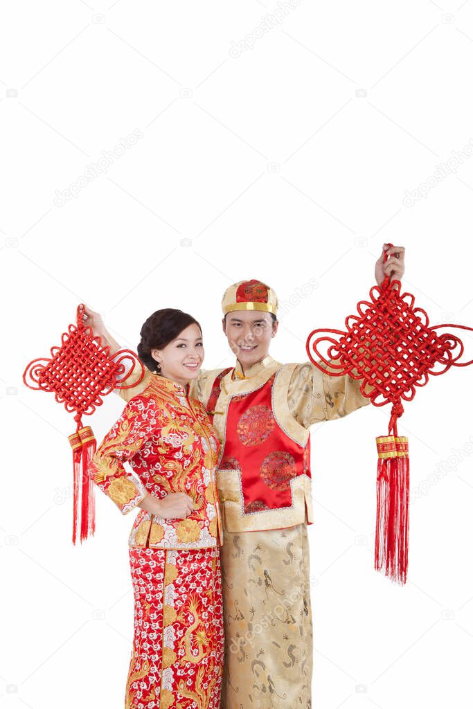 Portrait of young couple in Tang suits holding Chinese knots