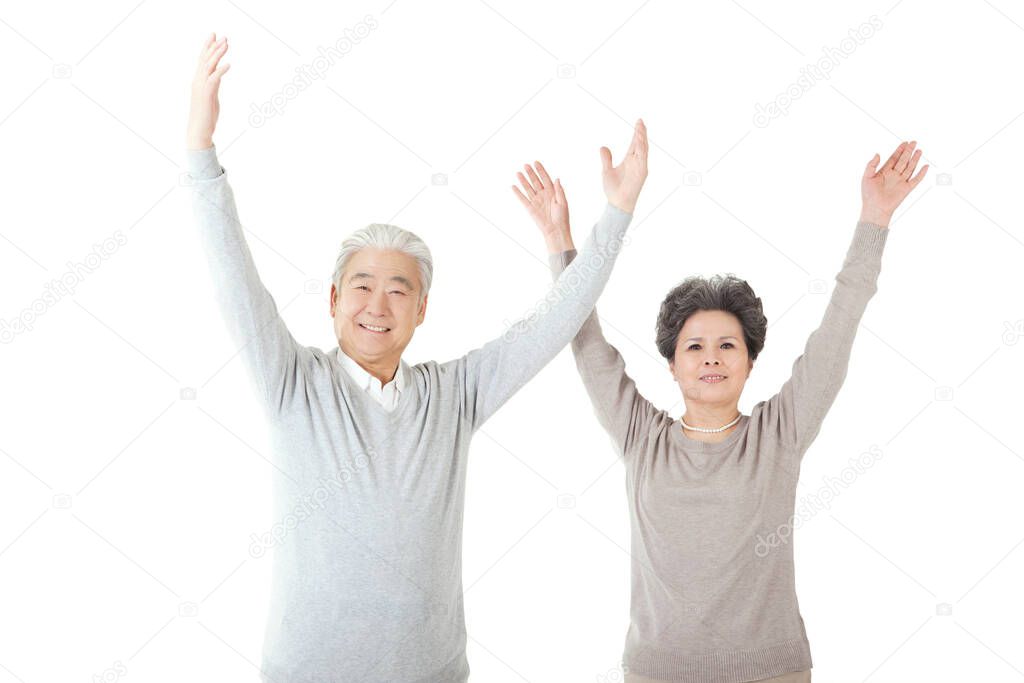 Oriental old couple with arms upraised