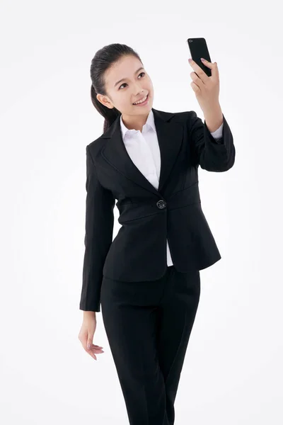 Orientalisk mode affärskvinna med hjälp av mobiltelefon själv timer — Stockfoto