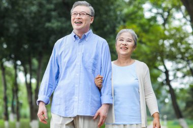 Parkta yürüyen mutlu yaşlı çift