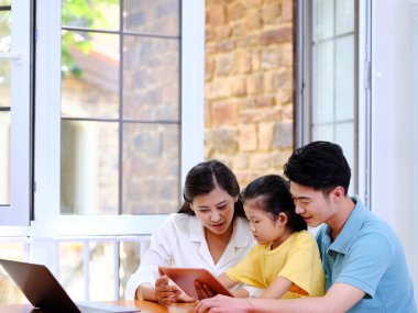 Üç kişilik mutlu bir aile tablet kullanıyor.