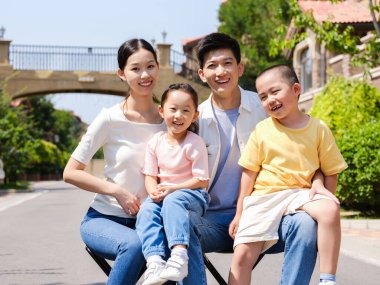 Açık hava grup fotoğrafında dört kişilik mutlu bir aile.