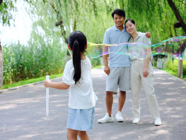 Parkta üç kişilik mutlu bir aile oynuyor. — Stok fotoğraf