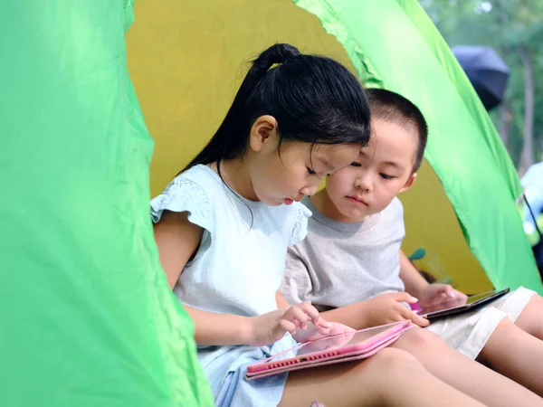 两个孩子在帐篷里玩平板电脑 — 图库照片