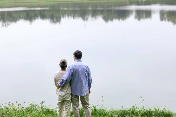 Ευτυχισμένο ηλικιωμένο ζευγάρι που βλέπει το τοπίο δίπλα στη λίμνη — Φωτογραφία Αρχείου