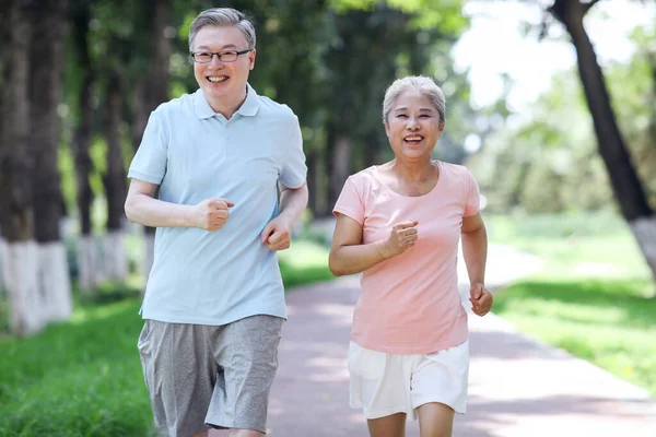 Oud koppel joggen in openlucht park — Stockfoto