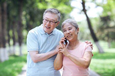 Mutlu yaşlı çiftler dışarıyı aramak için cep telefonu kullanırlar.