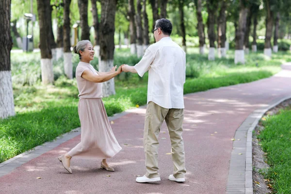 Un cuplu bătrân fericit dansând în parc — Fotografie, imagine de stoc