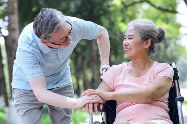 那位老人把他的妻子推上轮椅 — 图库照片