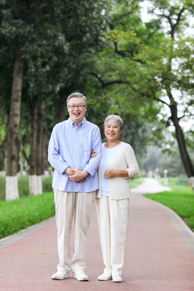Szczęśliwa stara para spacerująca po parku — Zdjęcie stockowe