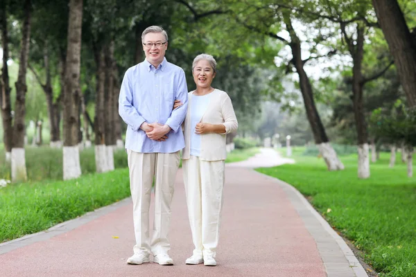 Szczęśliwa stara para spacerująca po parku — Zdjęcie stockowe