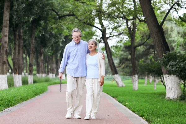 Счастливая старая пара, гуляющая по парку — стоковое фото