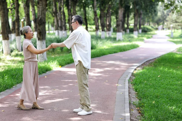 Happy old couple dancing in the park — Stock Photo, Image