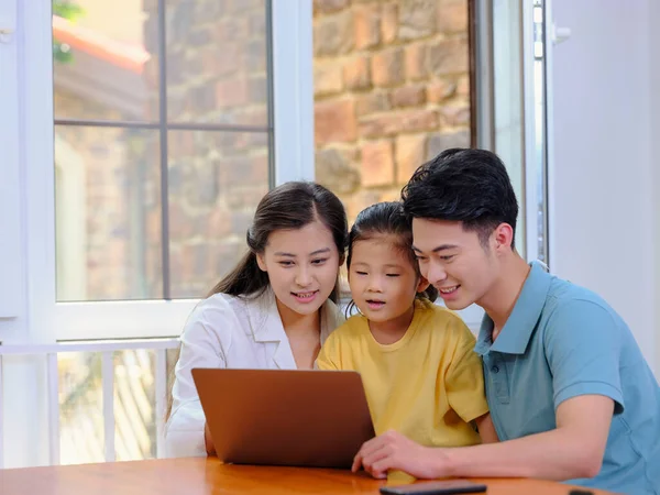 Eine glückliche dreiköpfige Familie mit Laptop — Stockfoto