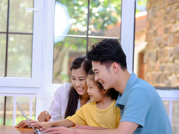 Uma família feliz de três usando laptop — Fotografia de Stock